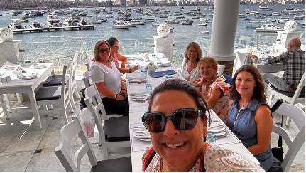 A selfie of a group of women eating lunch on the water in Egypt.