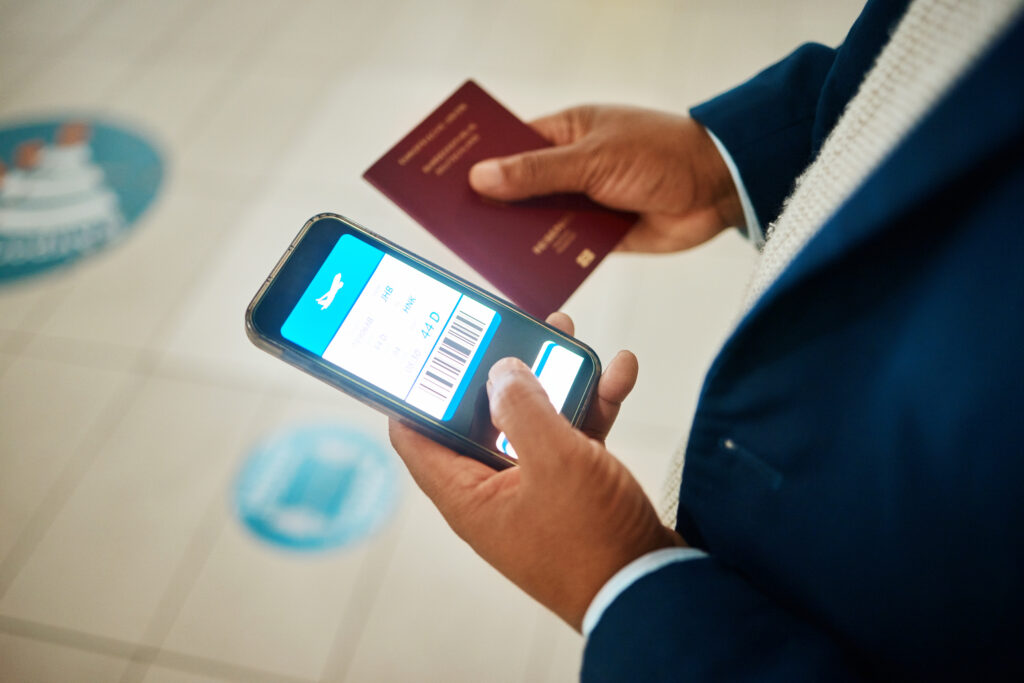 Person holding smartphone in left hand and passport in right hand trying to use the new Electronic Travel Authorization.